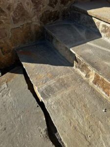 the image shows the stonework of steps being constructed with a focus on durability and aesthetic design for a custom home