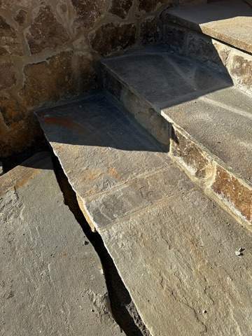 the image shows the stonework of steps being constructed with a focus on durability and aesthetic design for a custom home