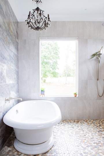 this service showcases a luxurious bathroom design featuring a freestanding tub natural light and elegant finishes