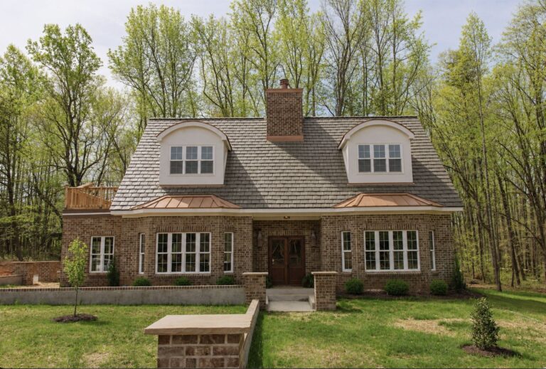 The Narnia House by WOLFE: front elevation with brick, dormers and copper roof accents