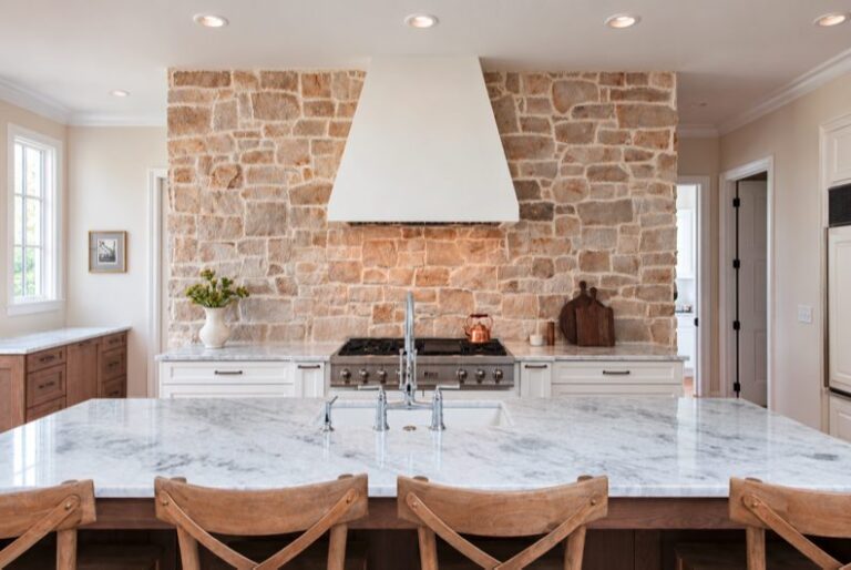 The Legacy by WOLFE: kitchen with a stone range wall and marble island